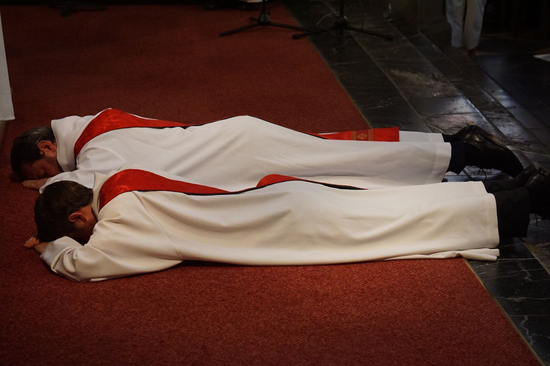 Lors du rituel de l'ordination, Loïc et Guillaume s'allongent. Fabienne, une femme du Quart-Monde dit : « Il s’est vidé. Il s’est laissé remplir par le coeur de Jésus »